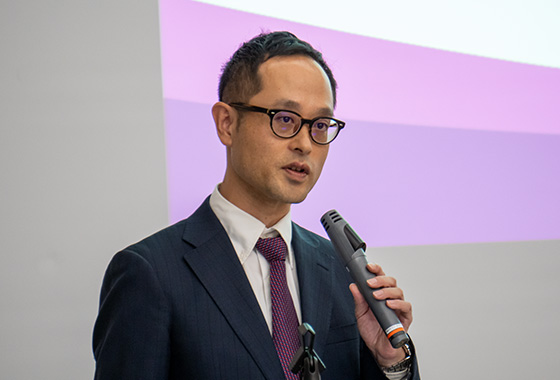 『阪急阪神のオフィスサミット2025』の会場で、マイクを手に講演を行う登壇者の様子。