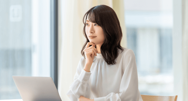 顎に手を添えて考え込んでいる女性