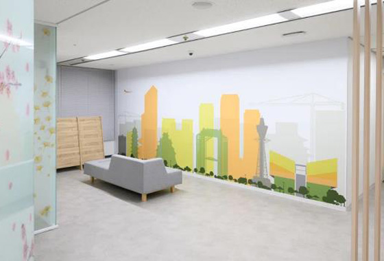 明るい色彩で都市景観が描かれたラクスの新オフィスのリラックスエリア。