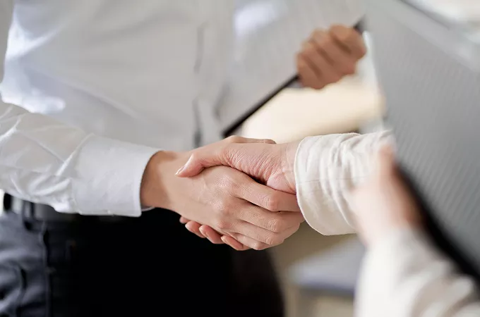 企業担当者同士が握手をする様子